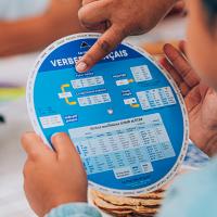 Enfant consultant la conjugaison d’un verbe avec la roue des verbes français